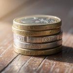 Monedas de euro apiladas sobre una superficie de madera