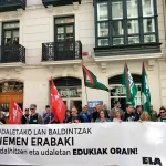Manifestantes con pancarta y banderas frente a Eudel.
