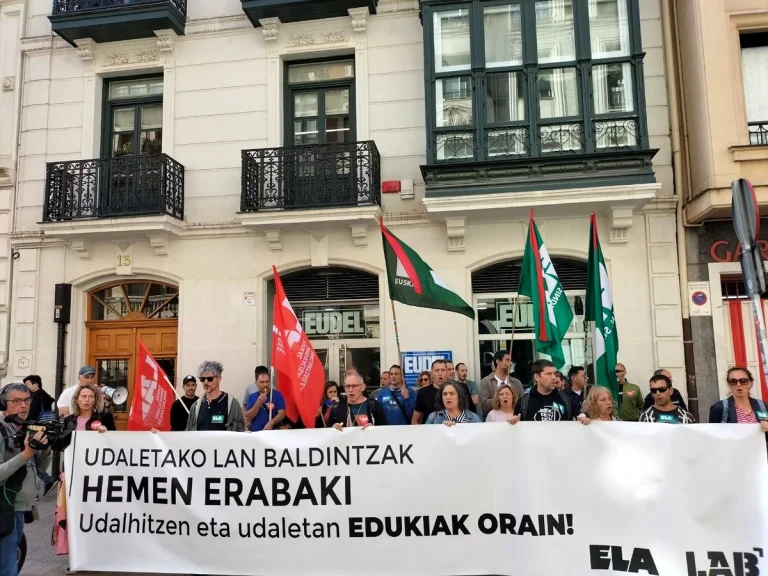 Manifestantes con pancarta y banderas frente a Eudel.