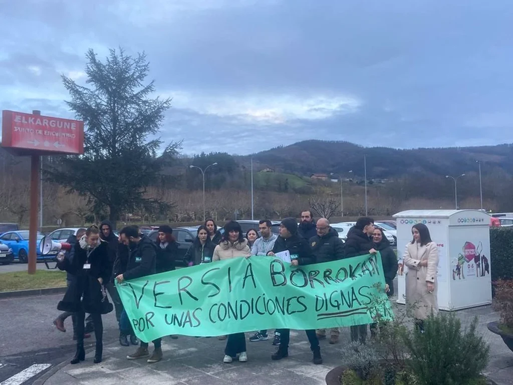 Grupo de trabajadores con pancarta en Versia Contact Center.