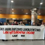 Manifestantes sosteniendo una pancarta en un edificio público