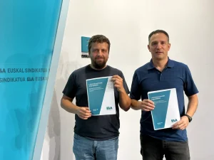 Dos hombres sosteniendo documentos en una presentación de ELA