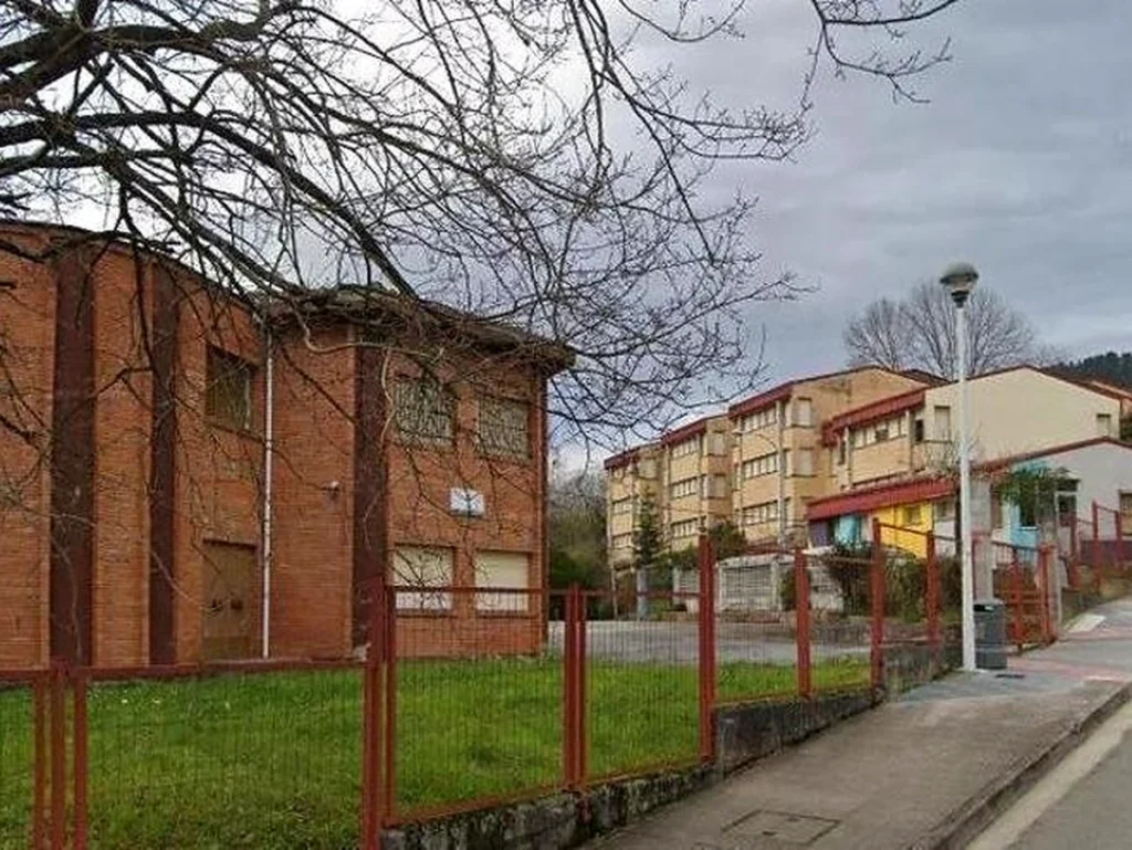 Edificio Laudio Goikoa con árboles y acera en primer plano