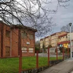 Edificio Laudio Goikoa con árboles y acera en primer plano