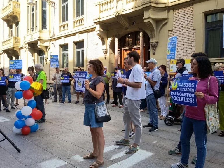 Manifestantes sosteniendo carteles en Iruñea contra la militarización