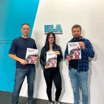 Tres personas sosteniendo un informe de ELA en un evento