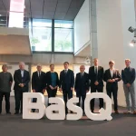 Grupo de personas posando junto al letrero BasQ en un evento