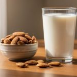 Vaso de leche junto a un cuenco de almendras en una mesa