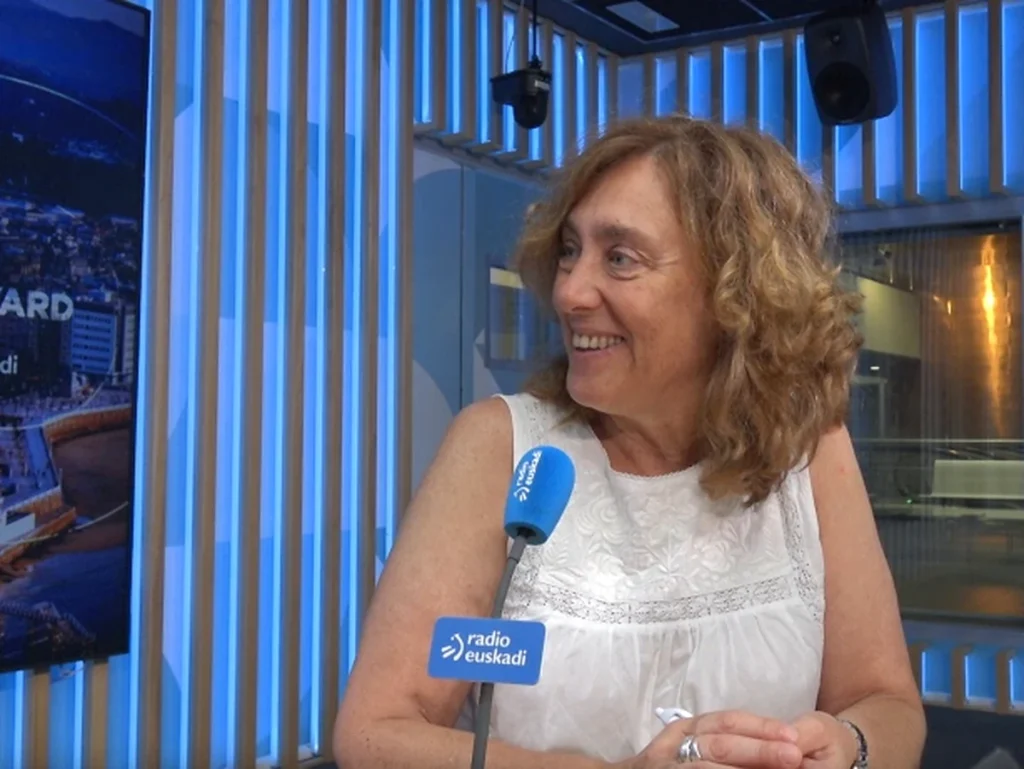 Mujer sonriente en un estudio de radio con micrófono azul