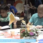 Dos personas en una mesa revisando documentos en un evento