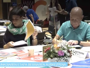 Dos personas en una mesa revisando documentos en un evento