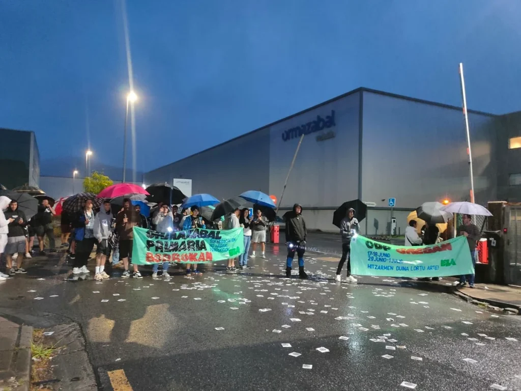 Grupo de trabajadores con paraguas protestando frente a Ormazabal.