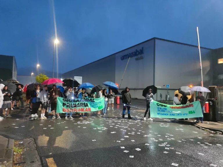 Grupo de trabajadores con paraguas protestando frente a Ormazabal.