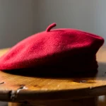 Boina roja sobre una mesa de madera clara