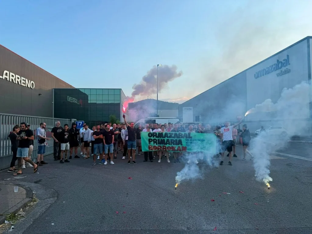 Grupo de trabajadores en huelga frente a Ormazabal con pancarta y humo