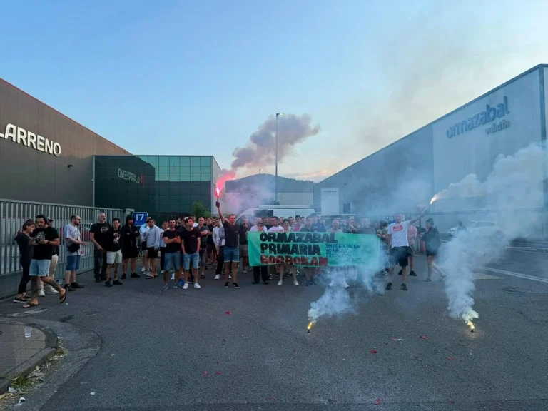 Grupo de trabajadores en huelga frente a Ormazabal con pancarta y humo