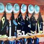 Casco y trajes de bomberos colgados en una pared