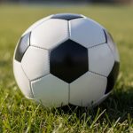 Balón de fútbol sobre césped verde en un campo de juego