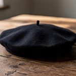 Boina negra sobre una mesa de madera clara