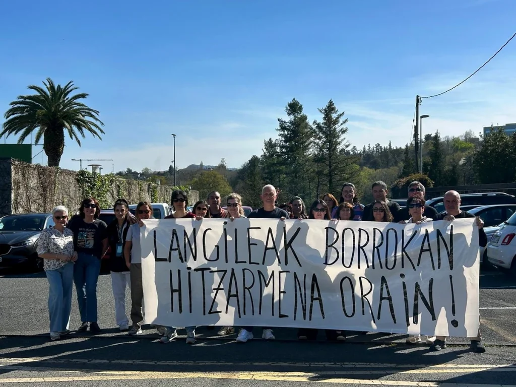 Grupo de trabajadores sosteniendo una pancarta en Donostia