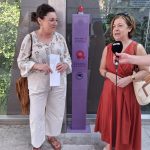 Dos mujeres de pie junto a un tótem de emergencia en Amorebieta-Etxano.