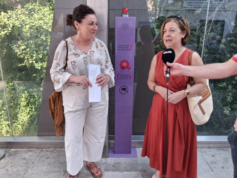 Dos mujeres de pie junto a un tótem de emergencia en Amorebieta-Etxano.