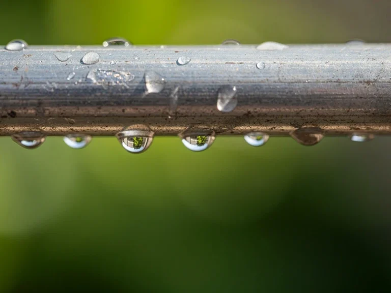 Gotas de agua sobre una tubería metálica brillante