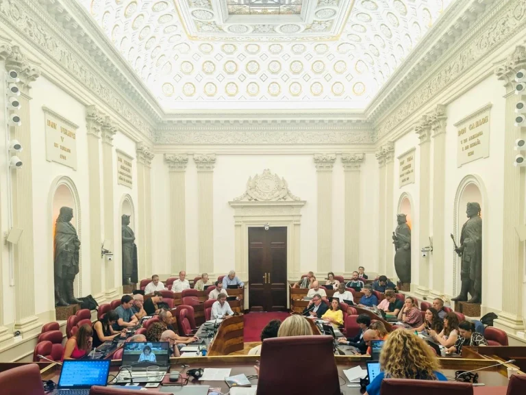 Sala de reuniones con personas sentadas y estatuas en las paredes