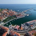 Vista aérea del puerto de Bermeo con barcos y edificios costeros.