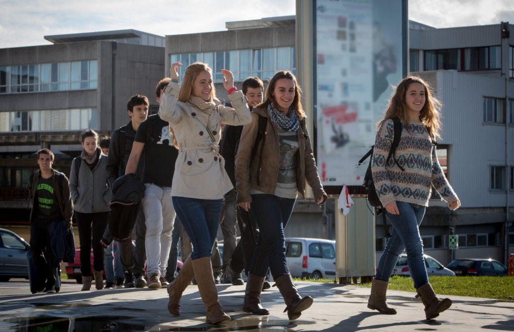 Grupo de estudiantes caminando por el campus universitario