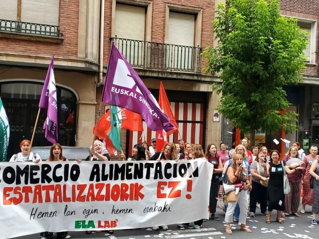 Manifestación con pancarta contra la estatalización laboral en comercio alimentario