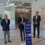 Tres personas en un evento sobre computación cuántica en Donostia.