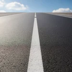 Carretera vacía con líneas blancas y cielo despejado