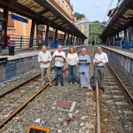Grupo de personas en una estación de tren con vías visibles
