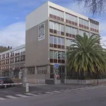 Edificio de Tubacex con palmeras y cielo despejado.