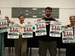Cuatro personas sosteniendo carteles de huelga en una conferencia