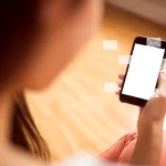 Mujer revisando su teléfono móvil con notificaciones de correo