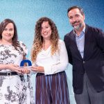 Tres personas posan con un premio en un evento de energía
