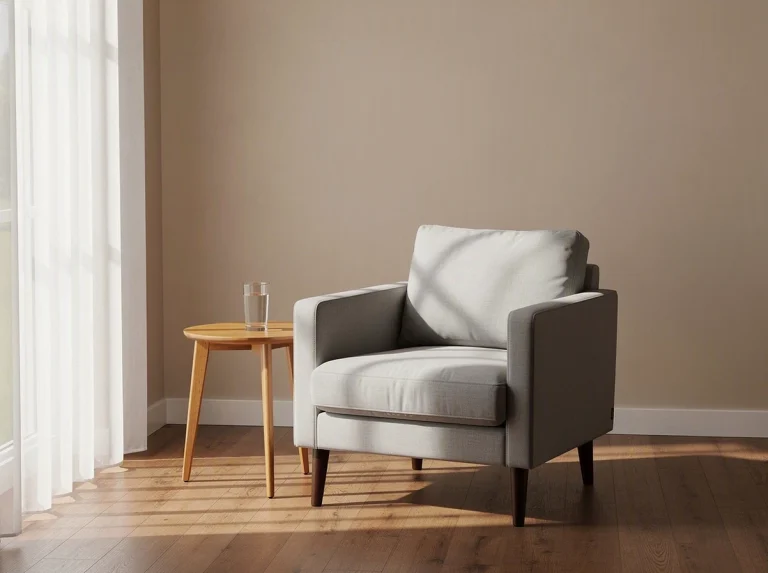 Sillón gris junto a una mesa de madera en una habitación iluminada
