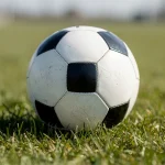 Balón de fútbol sobre un campo de hierba verde