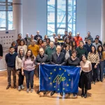 Grupo de personas sosteniendo una bandera de la UE en un evento