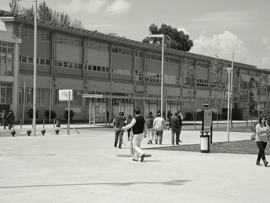 Grupo de personas en un campus universitario al aire libre.