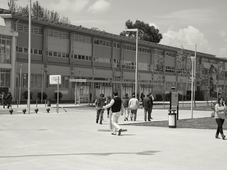 Grupo de personas en un campus universitario al aire libre.