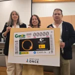Tres personas sosteniendo un cartel sobre el eclipse del 12 de agosto de 2026.