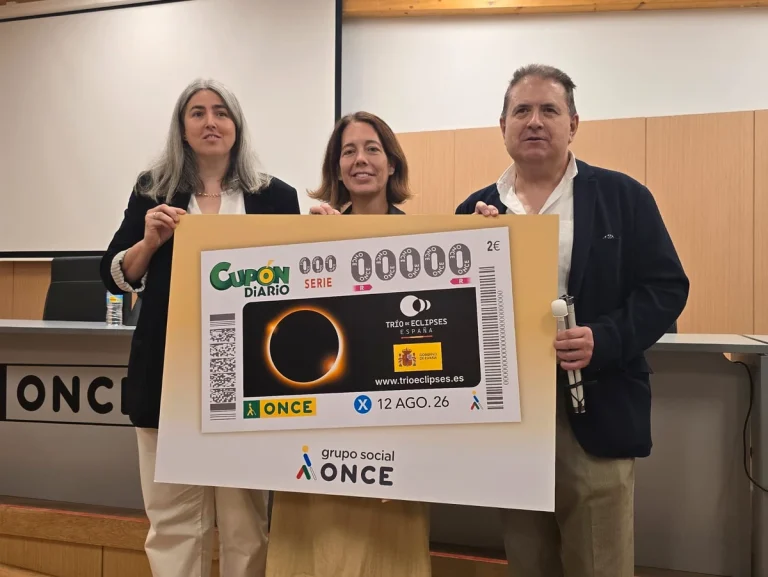 Tres personas sosteniendo un cartel sobre el eclipse del 12 de agosto de 2026.