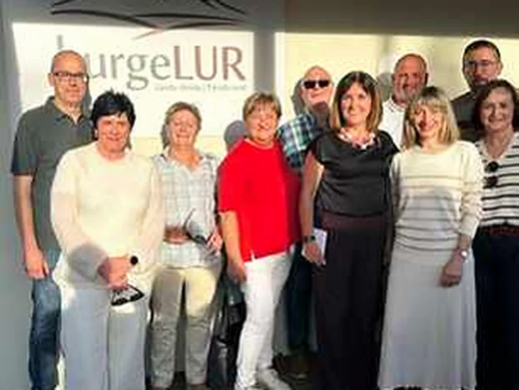 Grupo de personas posando frente al logo de BurgeLUR en Elburgo.