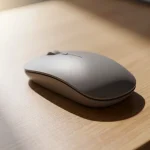 Raton inalámbrico gris sobre una mesa de madera clara