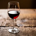 Copa de vino tinto sobre una mesa de madera