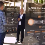Persona hablando frente a paneles sobre eclipses lunares