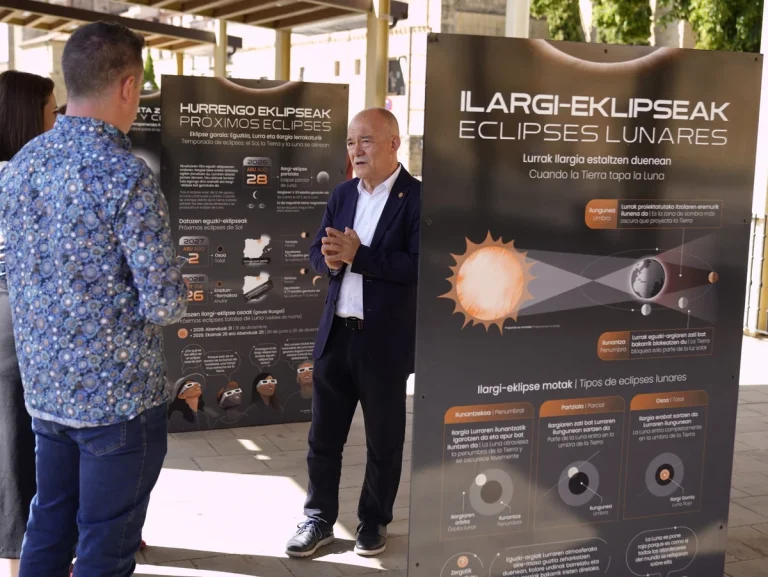 Persona hablando frente a paneles sobre eclipses lunares